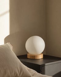Lampe de chevet boule blanche sur socle en bois clair