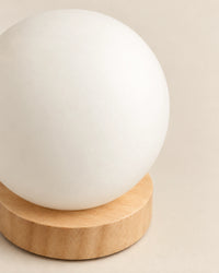 Lampe de chevet boule blanche sur socle en bois clair