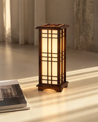 Lampe japonaise Shoji allumée dans une pièce aux rideaux clairs